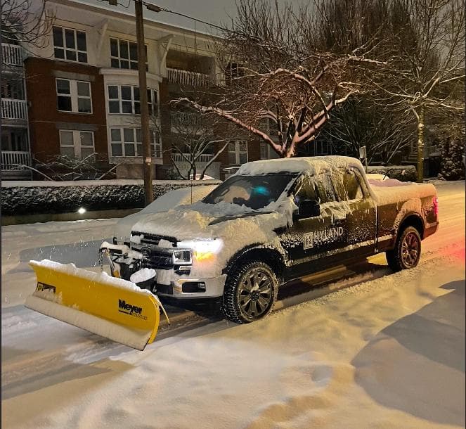 Hyland snow plow truck in action on snowy Vancouver street