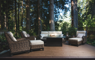 An image of a backyard deck with furniture beneath several large trees.