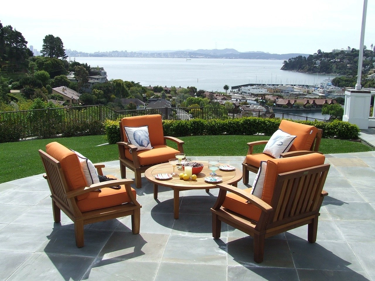 An image of a patio with a furniture set that has orange seat cushions.