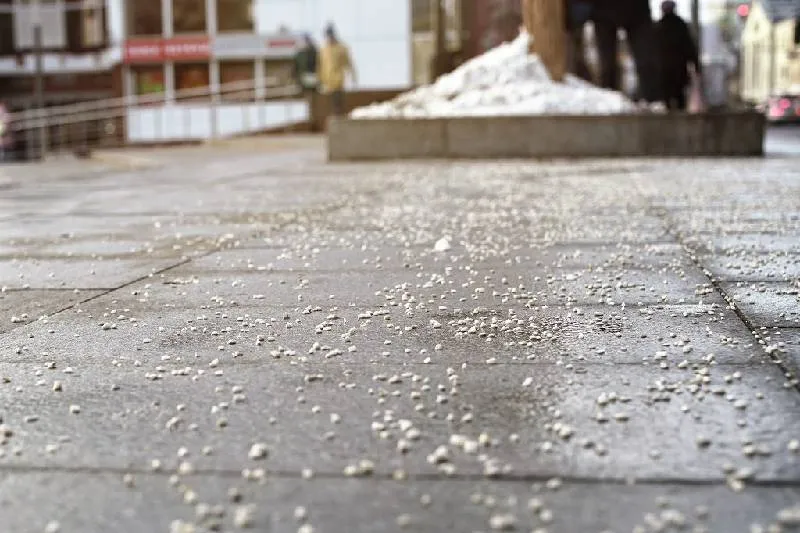An image of snow salt scattered on the pavement